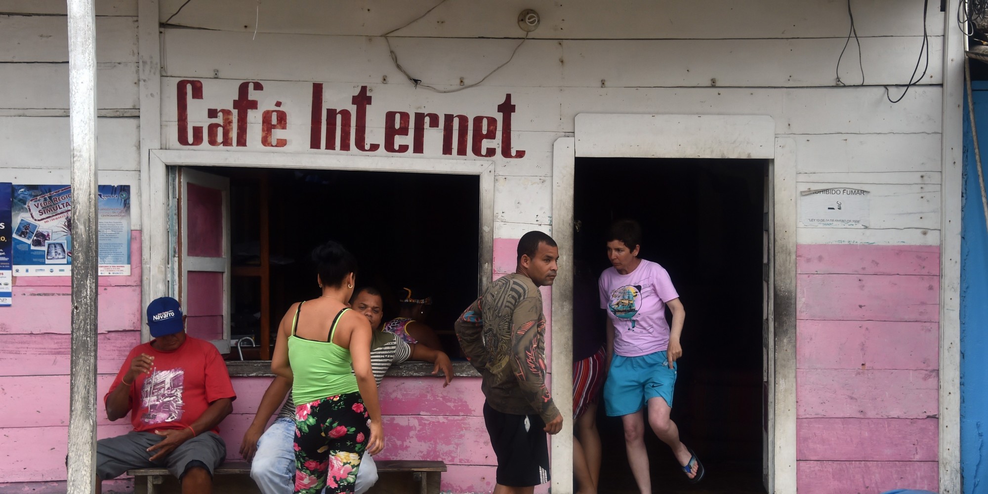 Cuban migrants wait outside an internet cafe in Puerto Obaldia, Guna Yala province, 300 km southeast of Panama City on May 14, 2015. Hundreds of Cubans cross every month the border from Colombia to Puerto Obaldia on boats on their way to the US. AFP PHOTO / Rodrigo ARANGUA        (Photo credit should read RODRIGO ARANGUA/AFP/Getty Images)